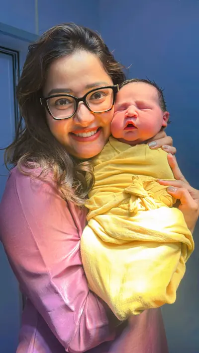 Dr. Deepika Rawat holding a newborn baby with a smiling mother
