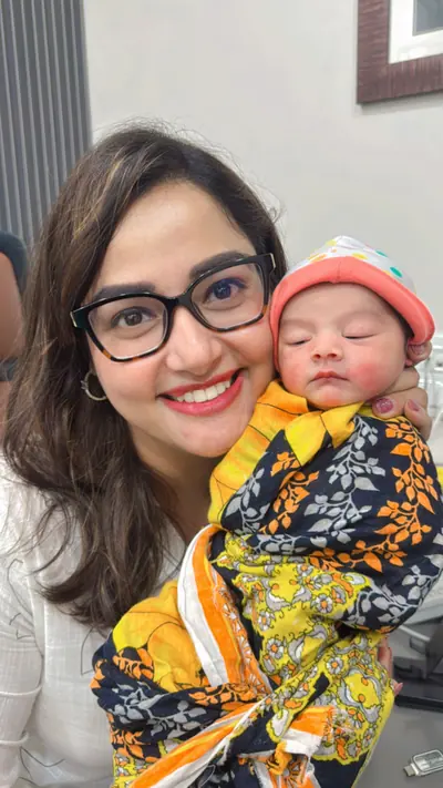 Dr. Deepika Rawat with a newborn wrapped in a blanket