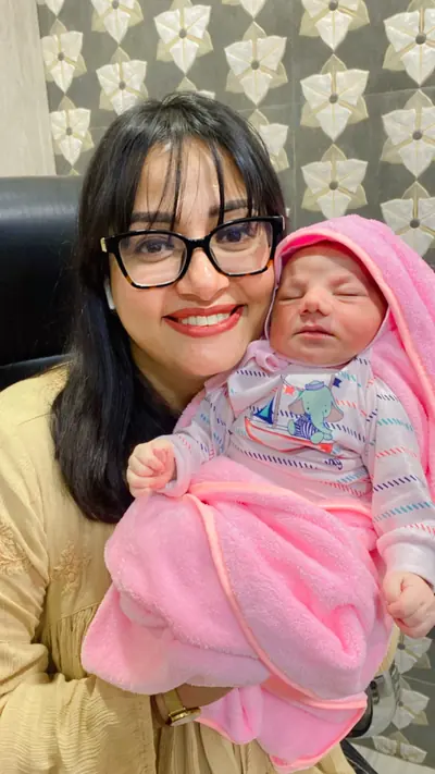 Dr. Deepika Rawat with a baby wrapped in a pink blanket