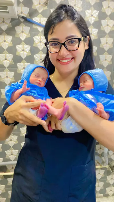 Dr. Deepika Rawat holding a laughing baby at the clinic